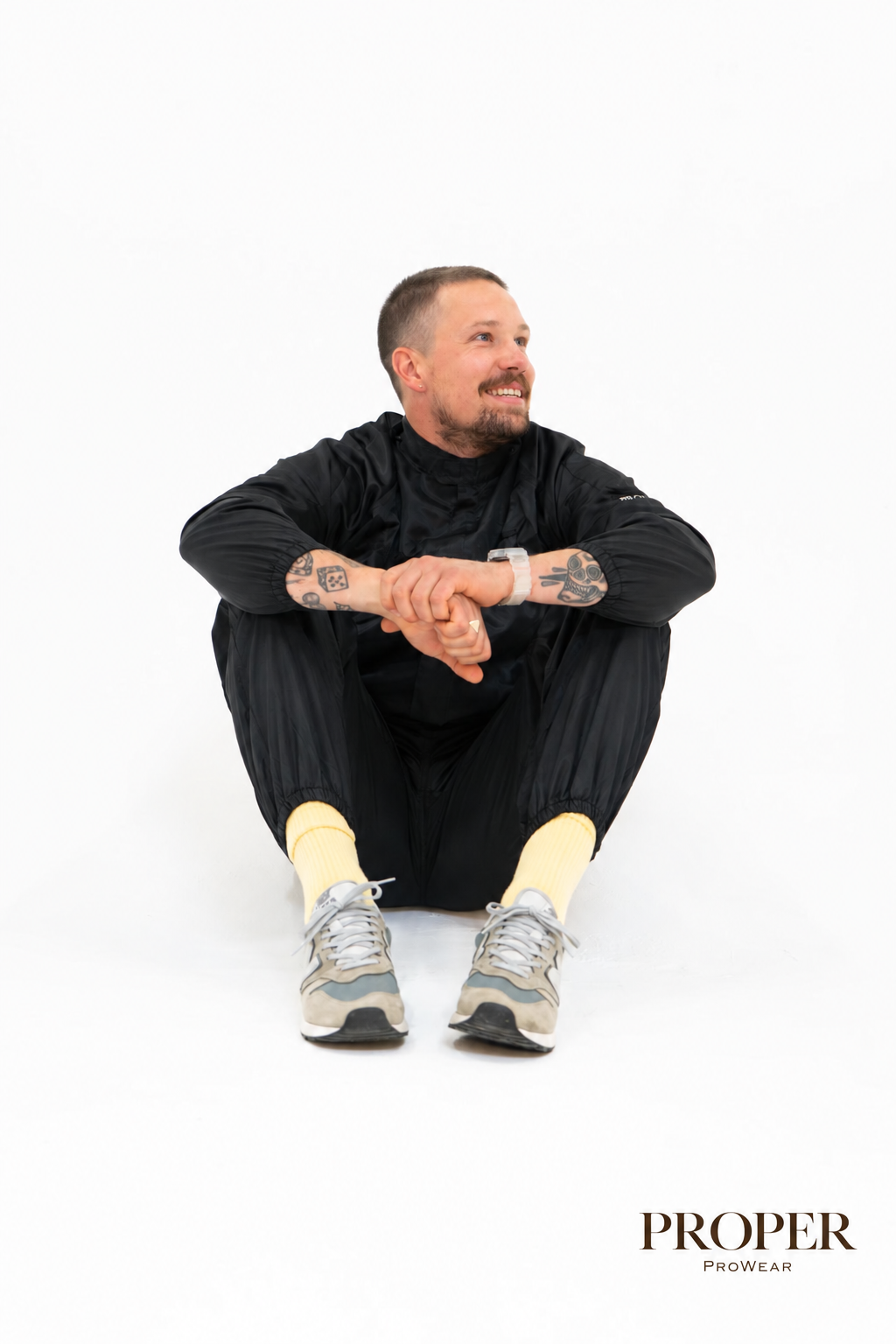 Barber sitting wearing the black Barber Armour hair-resistant top and trousers