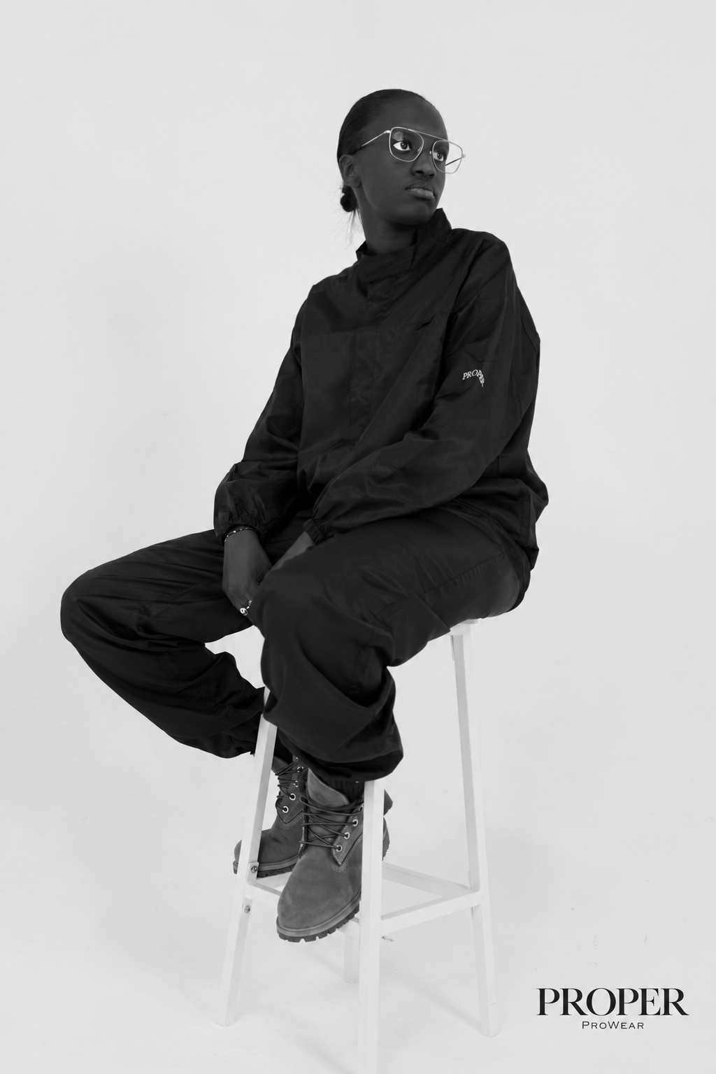 Barber seated on a stool wearing the Barber Armour hair-resistant suit with cuffed ankles