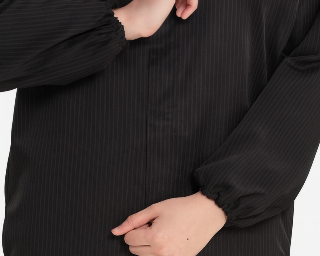 Black long-sleeve shirt with a close-up of the collar and sleeve on a white background.